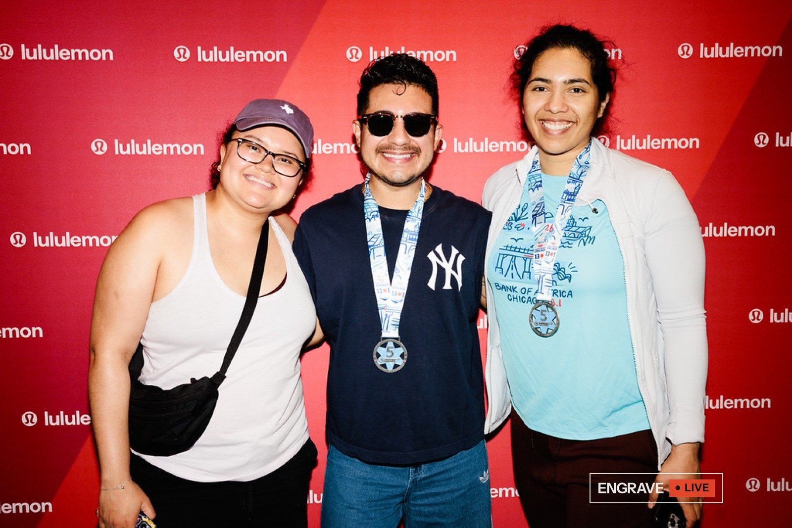 Three runners with their engraved finisher medals at the lululemon celebration.
